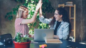 Two women celebrate success with a high five.
