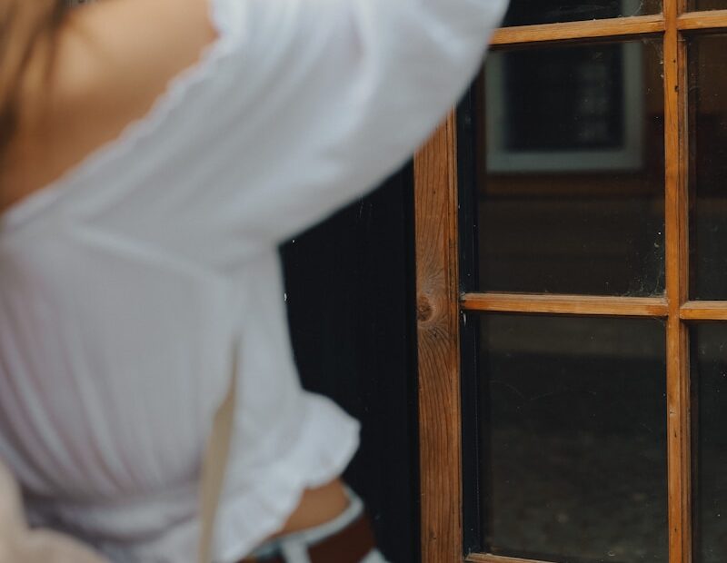 a woman standing in front of a door talking on a cell phone